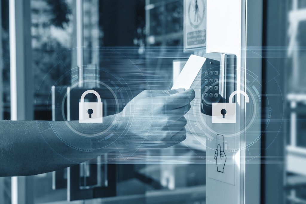 main tenant une carte d'accès magnétique d'entreprise pour ouvrir la porte. concept de sécurité de serrurerie